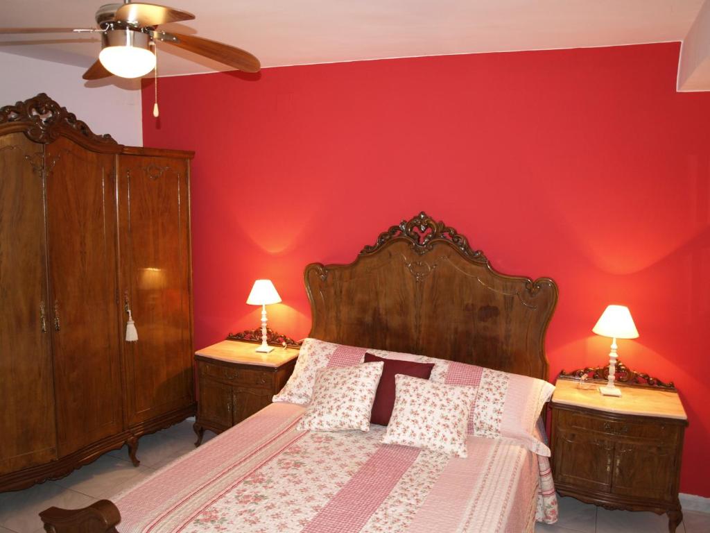 Sieste卡萨皮克罗乡村民宿的一间卧室配有一张红色墙壁的床