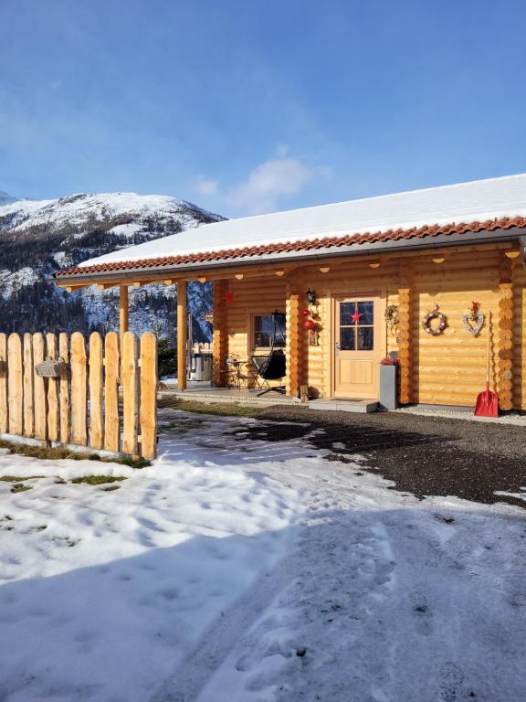 大基希海姆Connys Naturberghütten的雪中带围栏的小木屋