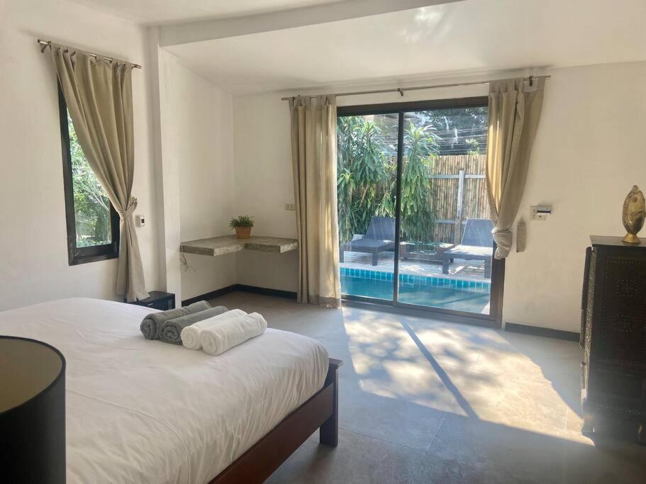 涛岛Bamboo Villa的一间卧室配有一张床,享有游泳池的景色