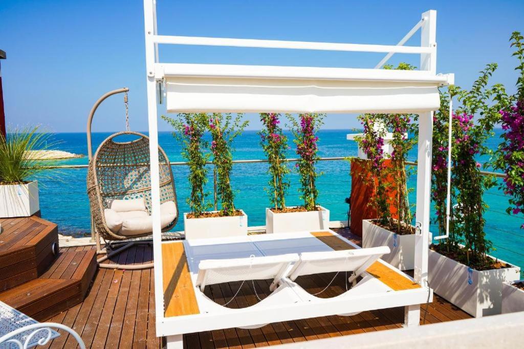 萨维勒特里Apulia Charming Suites - Casa Rossa Suite Perla e Suite Corallo的平台上的一张床铺,背景是大海