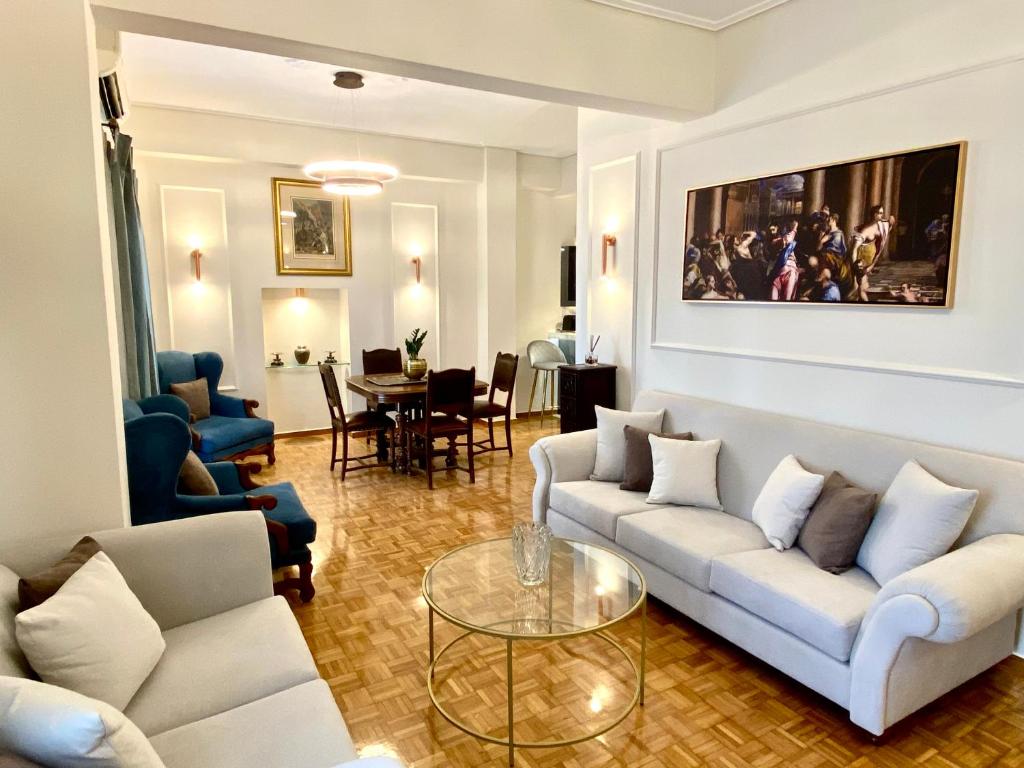雅典Athenian Condo的客厅配有白色的沙发和桌子