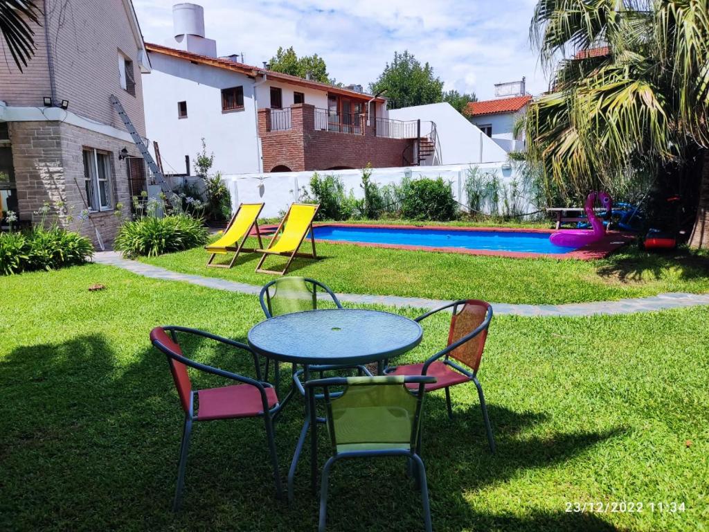 奥利沃斯hostel olivos的一个带游泳池的庭院里的桌椅