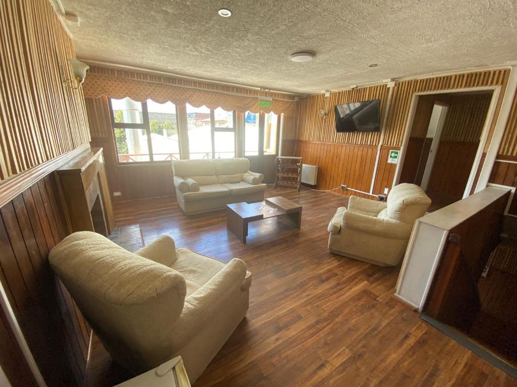 蓬塔阿雷纳斯Hostal Ochen的客厅配有两张沙发和一台电视