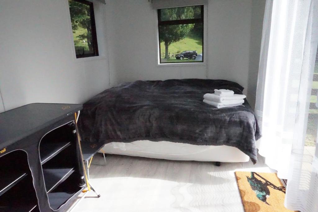 纳尔逊Cable Bay Farm的一间卧室配有一张带黑色毯子的床