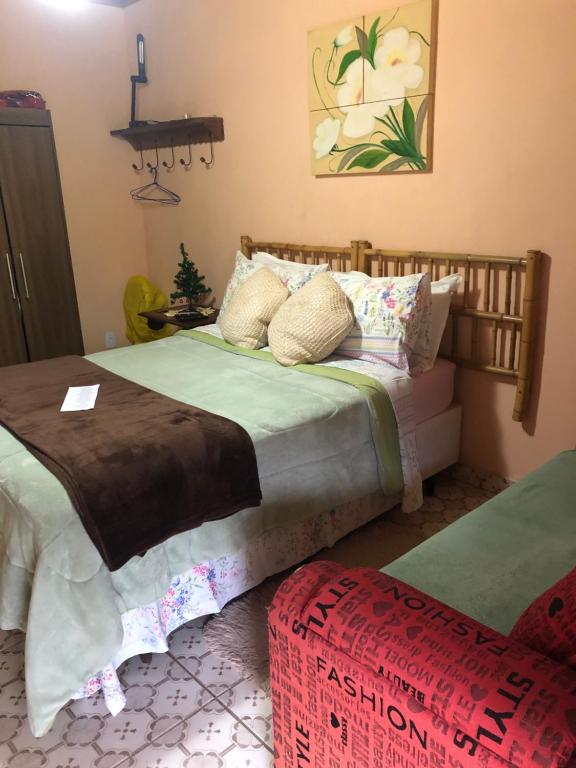 圣佩德罗塞拉Cantinho da Paz的一间卧室配有一张床和一张搁脚凳
