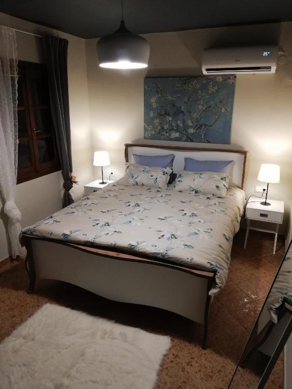 马克里尼撒Endless View Country House的一间卧室配有一张带两张桌子和两盏灯的床。