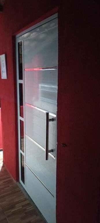 瓜拉米兰加Casa Friozinho da serra的红色房间中的一个冰箱门打开