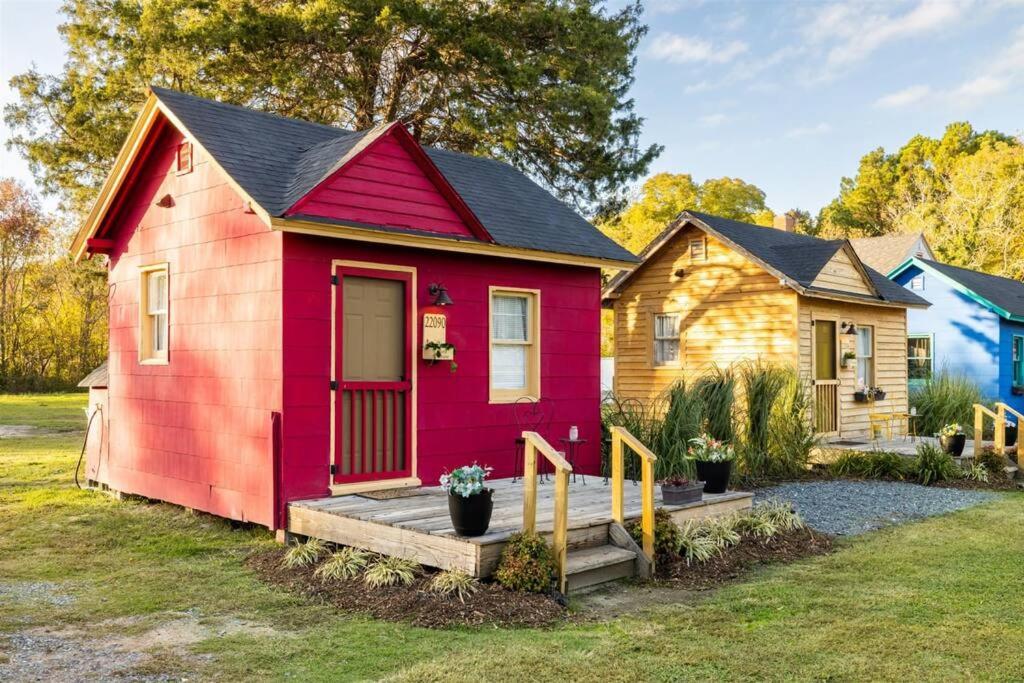 开普查尔斯Red House Tiny Home的红色和黄色的小房子,设有门廊