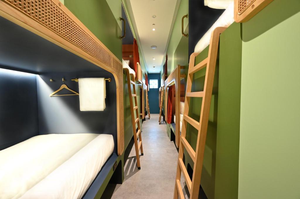 新加坡Dream Chaser Boutique Capsule Hotel的带两张双层床的客房,拥有绿色的墙壁