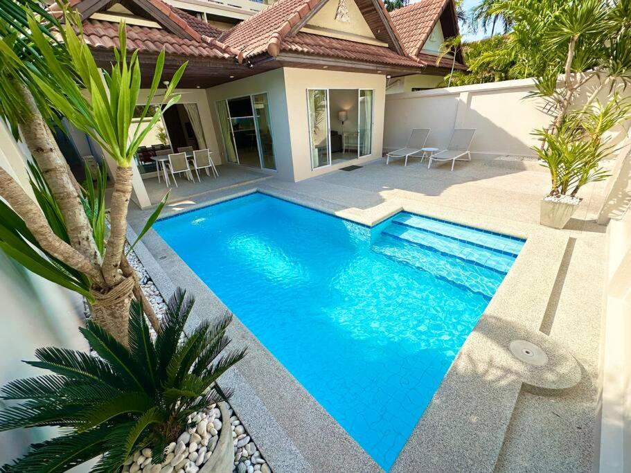 乔木提恩海滩View Talay Villas - Luxury 2BR pool villa nr beach - VTV 86的一座大型蓝色游泳池,位于房子旁边