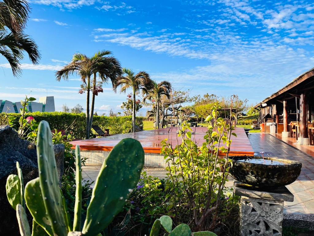 鹅銮鼻垦丁盘古拉渡假花园民宿的一座种有棕榈树的花园及一座建筑