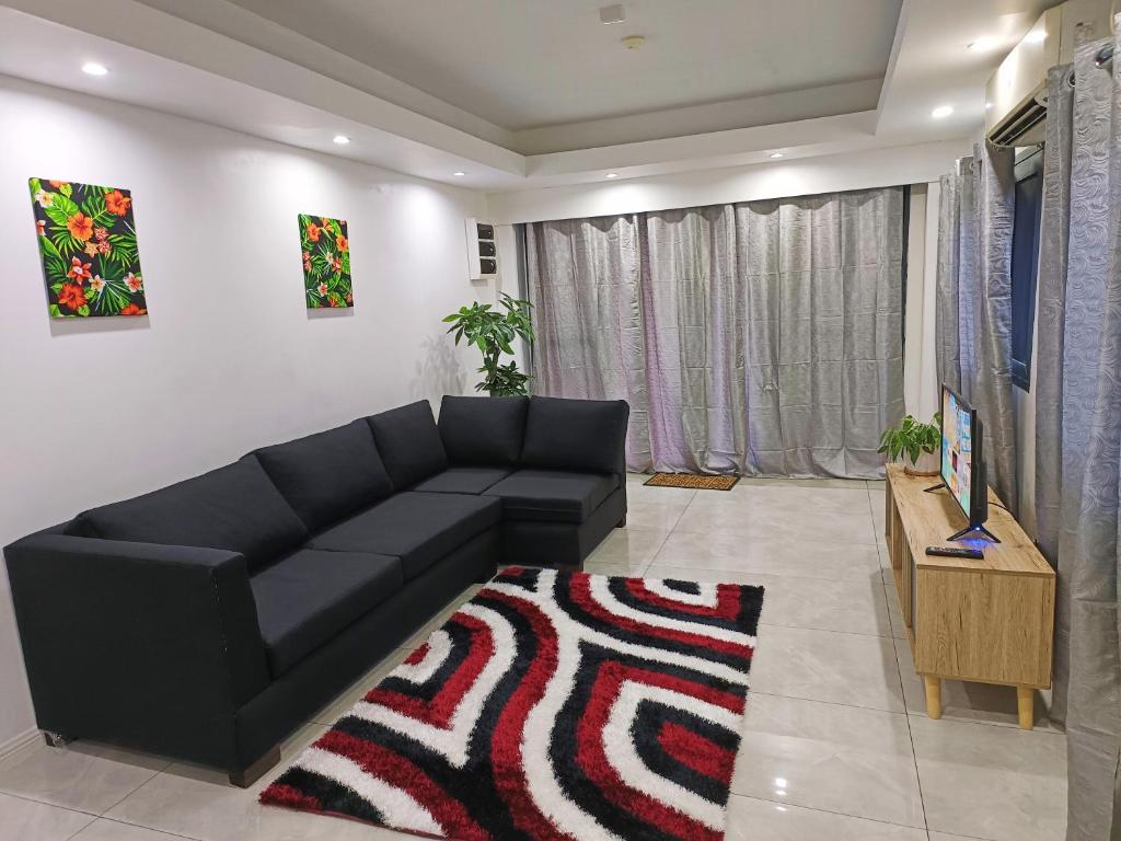 苏瓦Pacific Apartment的客厅配有黑色沙发和地毯。