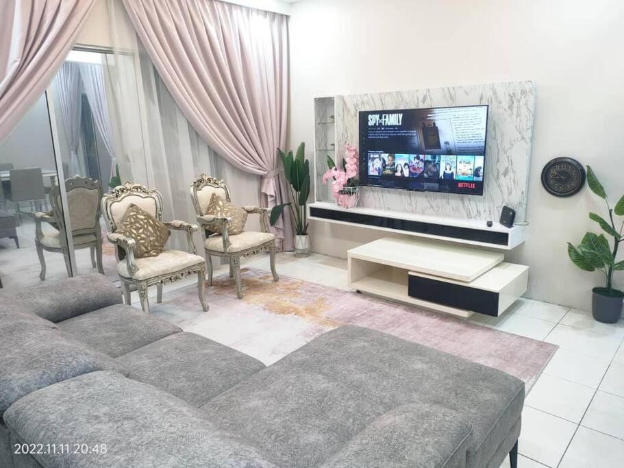 万挠Embun Bayu Musliim homestay的带沙发和平面电视的客厅