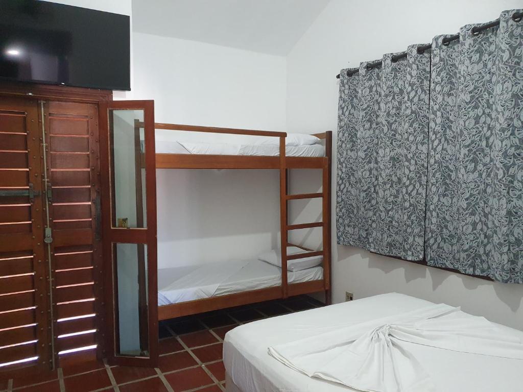 伊塔尼亚恩Royal-inn SPA & Pousada的一间卧室配有一张双层床、梳妆台和电视。