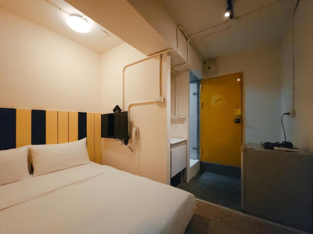 台北台北栈旅店的小房间,设有床和黄色门