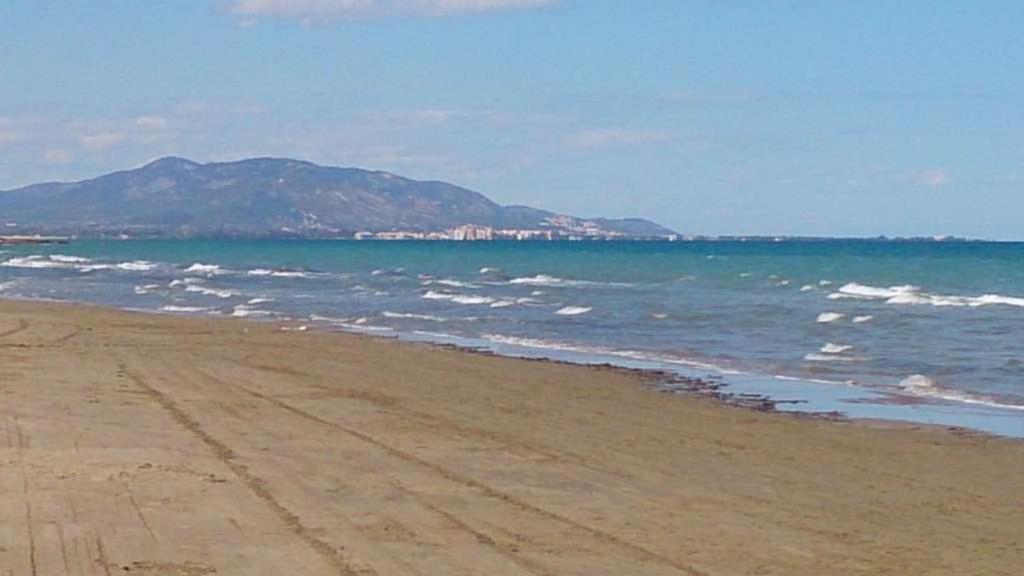 卡瓦内斯Bajo con gran terraza en Ribera de Cabanes的大海和山底的海滩