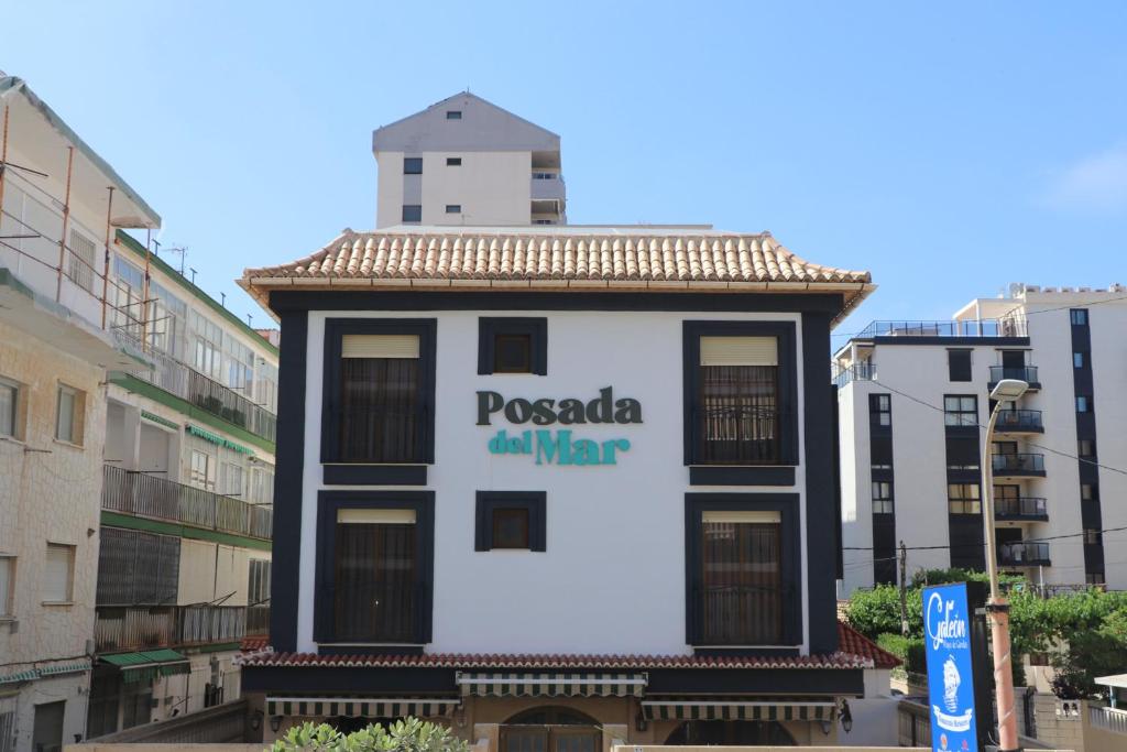 甘迪亚海滩101 I Posada del Mar I Encantador hostel en la playa de Gandia的一座有标志的建筑,上面写着波科奇的战争