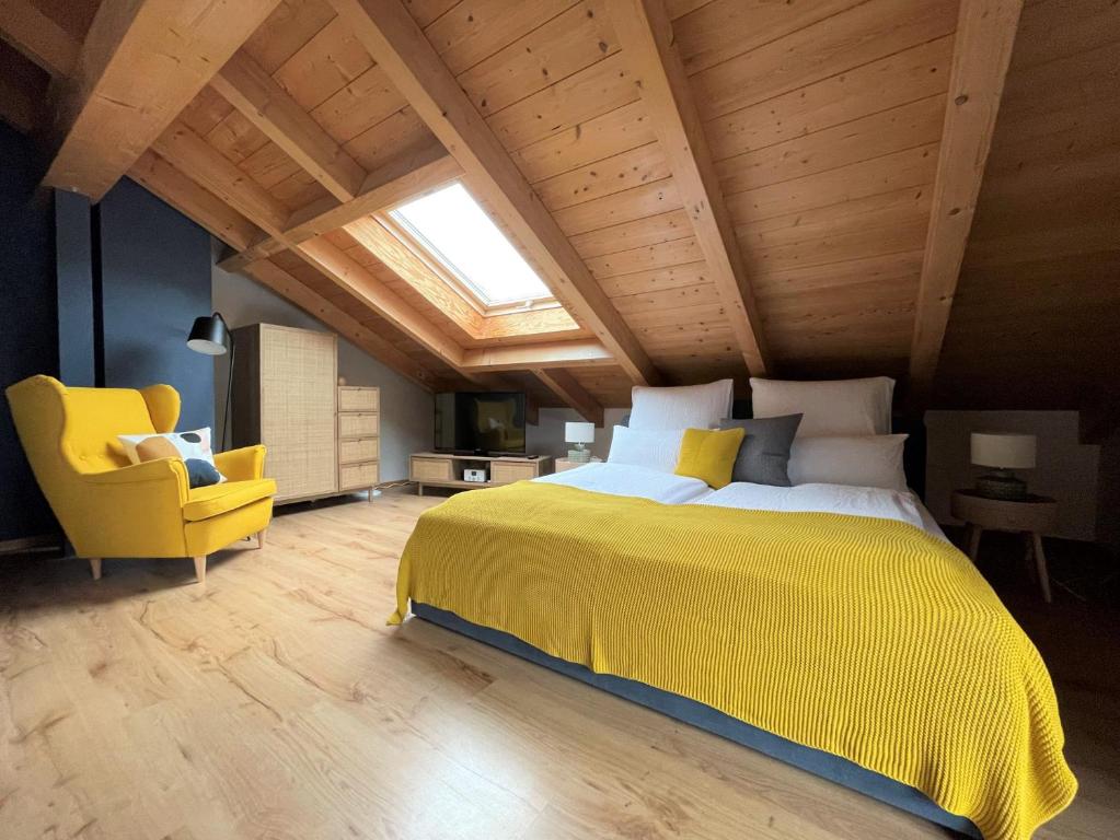 奥伯劳Das Bergquartier - Ferienwohnung Mühlberg的一间卧室配有黄色的床和黄色的椅子