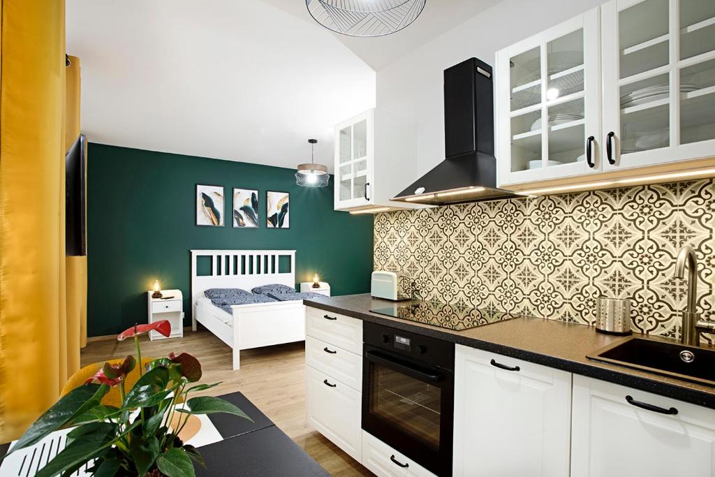 弗罗茨瓦夫Na zielonym Widoku的一间厨房,配有白色的橱柜和一张位于客房内的床