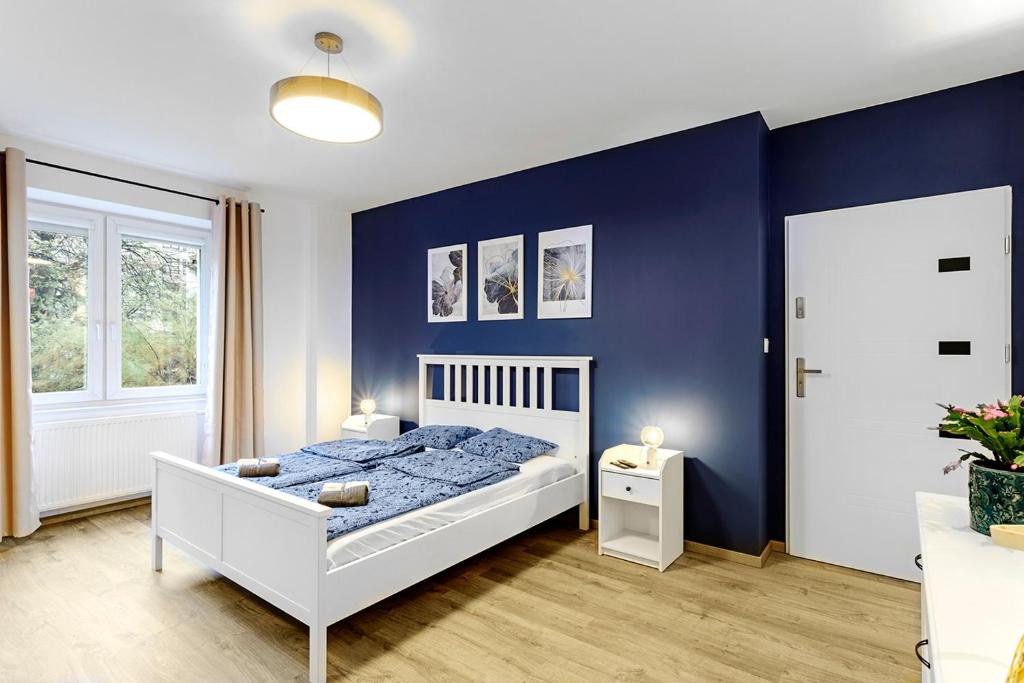 弗罗茨瓦夫Na niebieskim Widoku的卧室配有白色的床和蓝色的墙壁