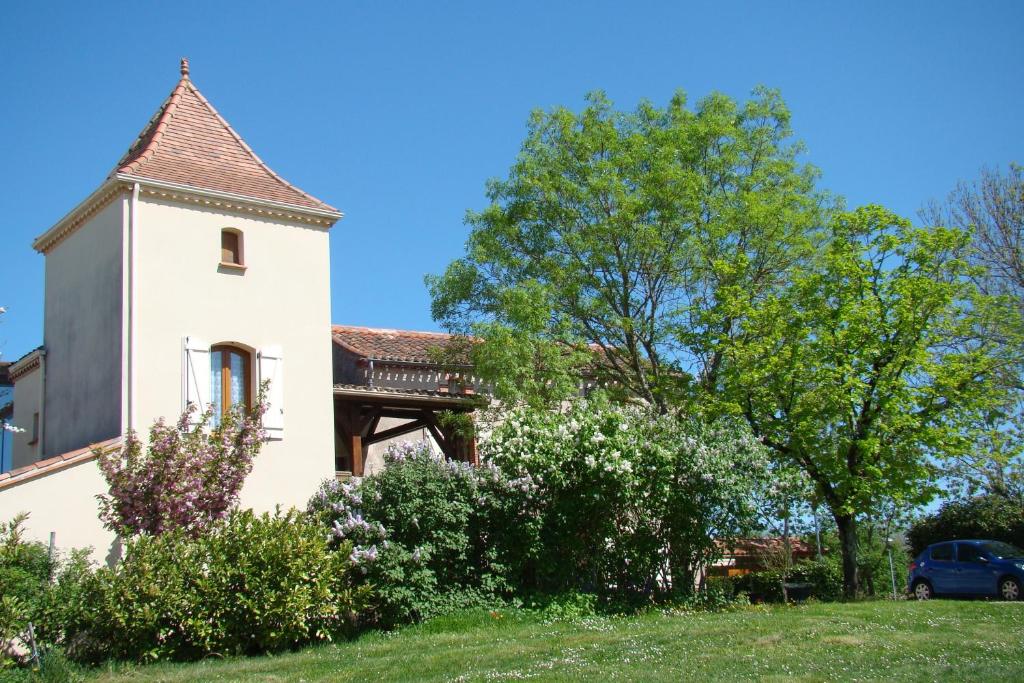 圣皮尔拉菲CHAMBRES D'HOTES LES GRAVES的一座白色的房子,有塔和树木