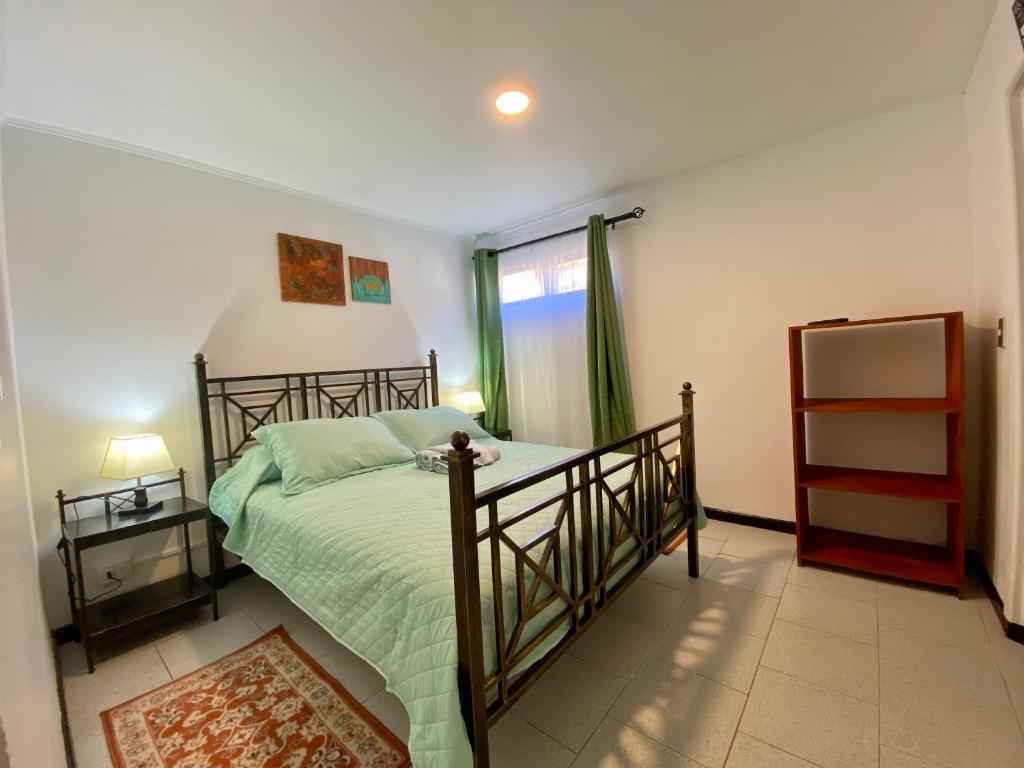 皮奇勒姆Hostal Dolegant Pichilemu 2的一间卧室配有一张带绿色床单的床和一扇窗户。