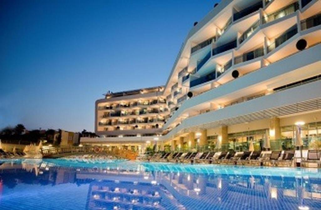 阿萨拉尔Selene Beach & Spa Hotel - Adult Only - Ultra All Inclusive的大型酒店,在晚上设有大型游泳池