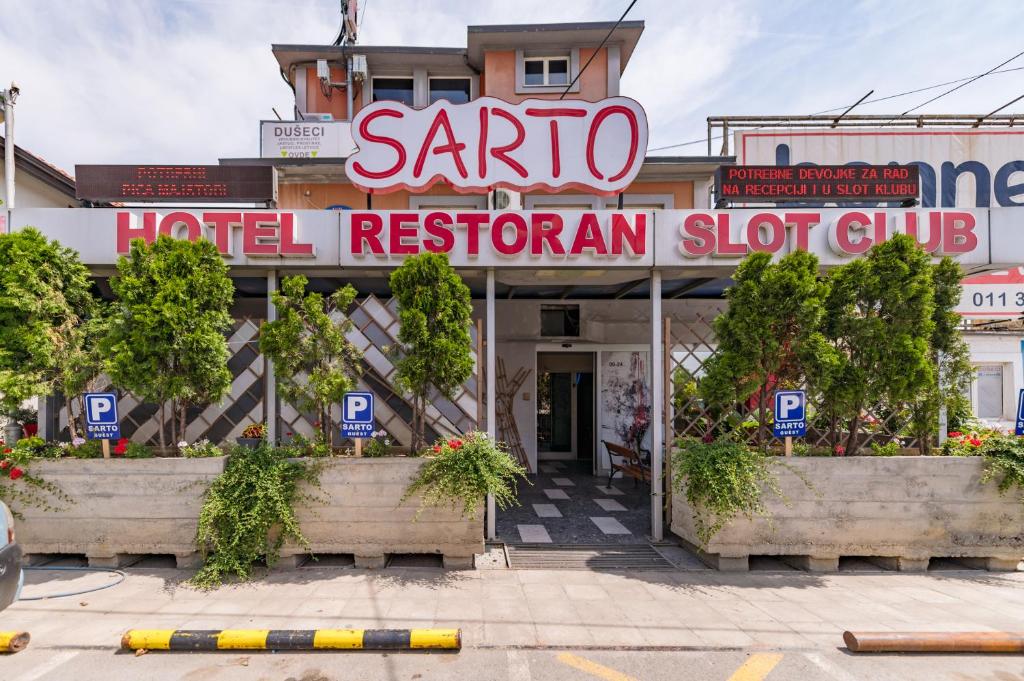 贝尔格莱德Hotel Villa Sarto的一间酒店餐厅,上面有标志,上面写着桑塔酒店洗手间俱乐部的读物