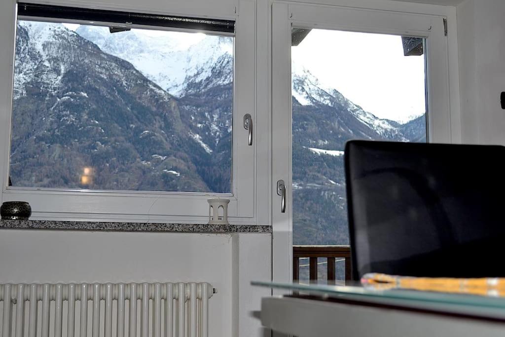 奥斯塔Grazioso appartamento Aosta的一间带电视和2扇窗户的客厅