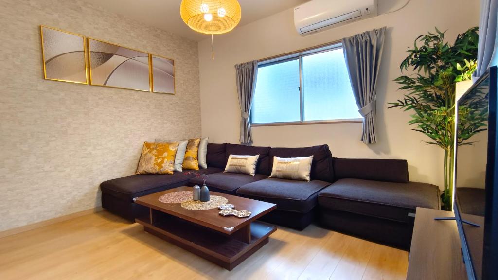 大阪Tsukiyume Kan - House with Parking, 10Mins to USJ, Tennoji, Namba的客厅配有沙发和桌子