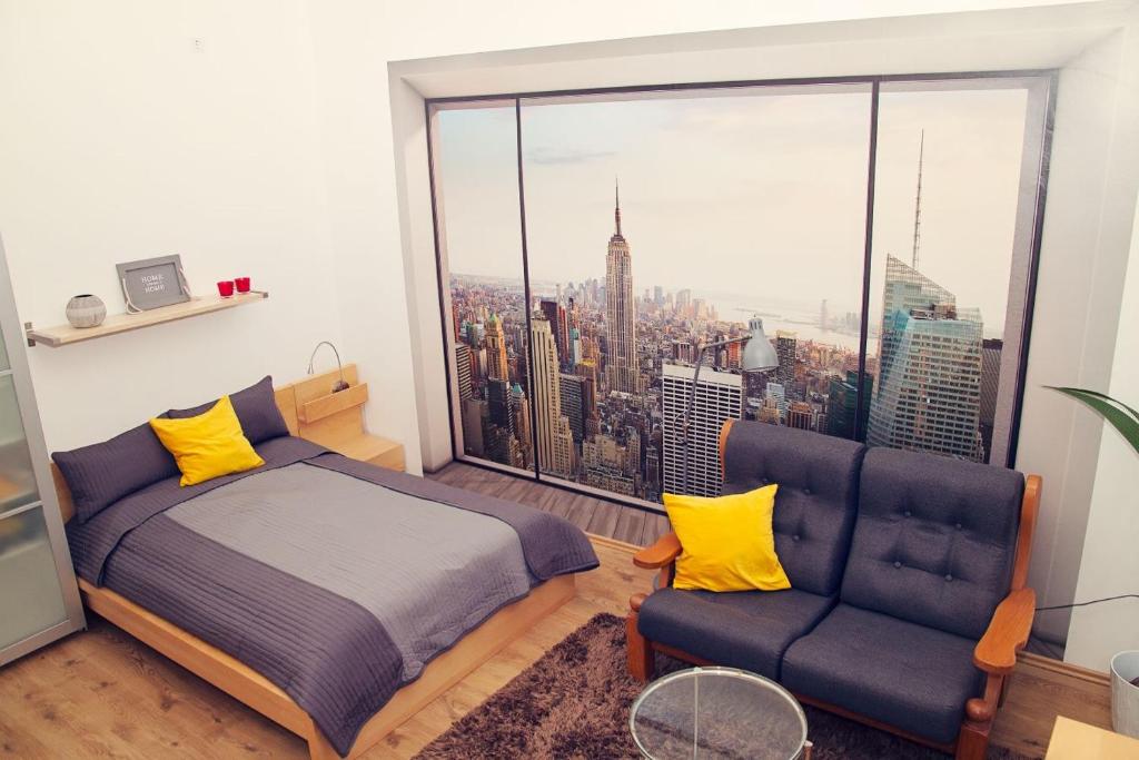 布达佩斯Trendy & Cozy Apartment at Heroes' Square的一间卧室配有一张床、一张沙发和一个大窗户