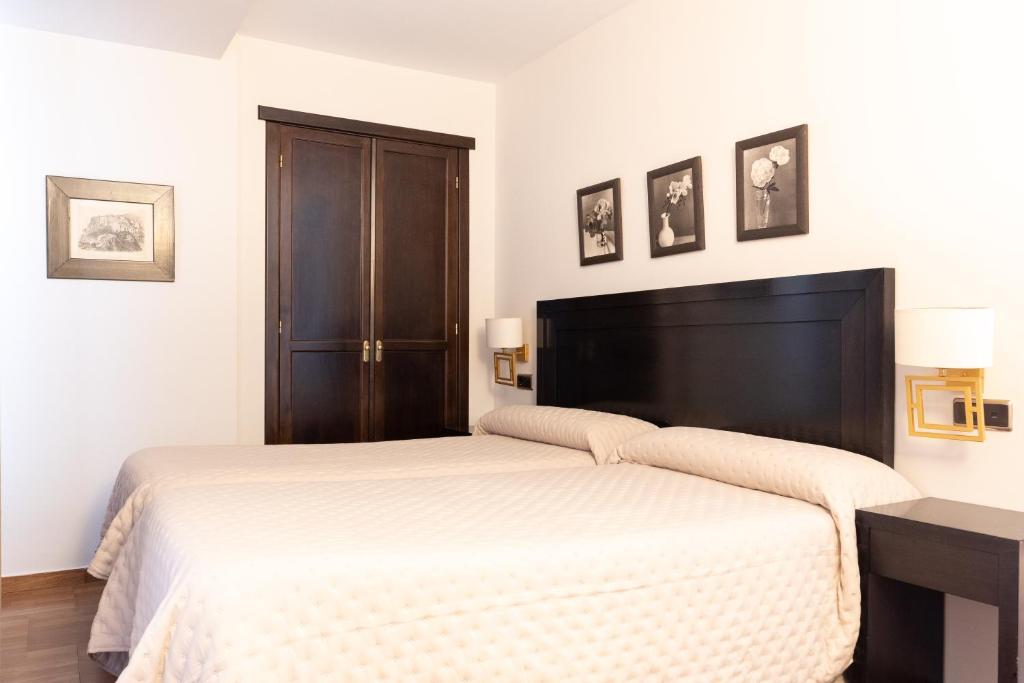 马尔莫莱霍广场旅馆的一间卧室配有一张白色的床和黑色床头板