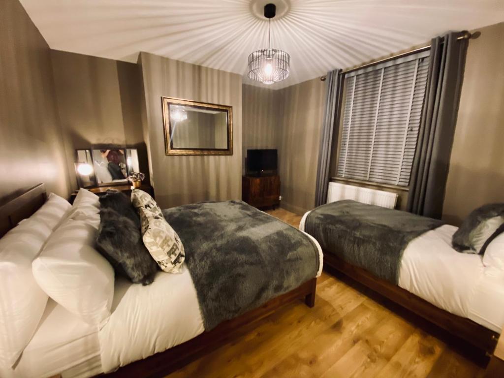 毕晓普奥克兰The Etherley - Zillo的一间卧室配有两张床和吊灯。