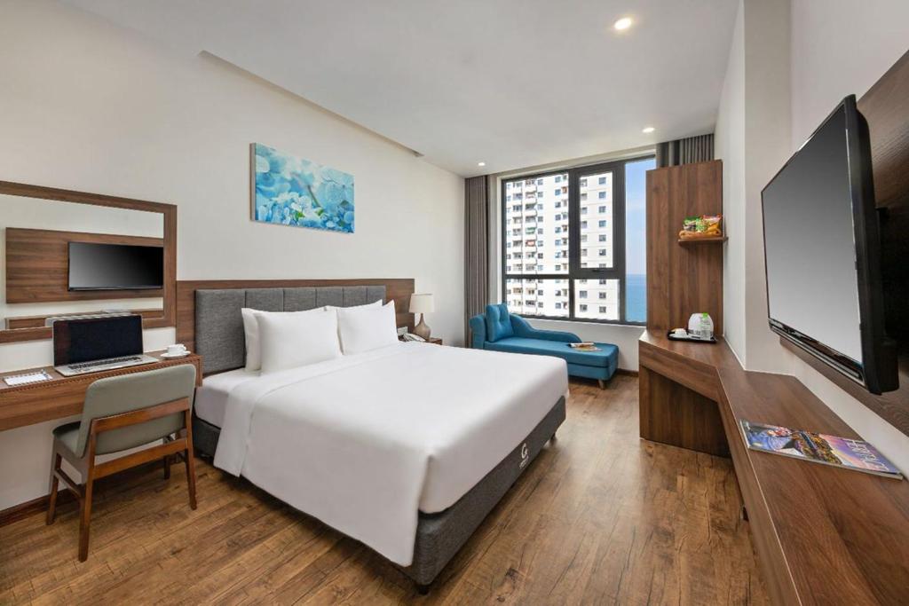 岘港Capecia Danang Hotel and Apartment的酒店客房设有一张床、一张书桌和一台电视机。
