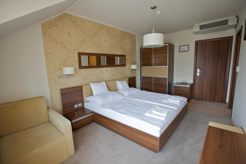 豪伊杜索博斯洛佩泽欧健身机场酒店的一间卧室配有一张大床和一把椅子