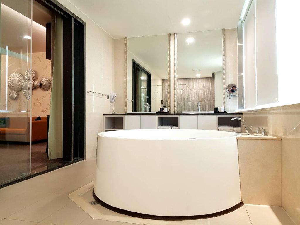中和集瑷饭店的一个带镜子的浴室内的白色大浴缸