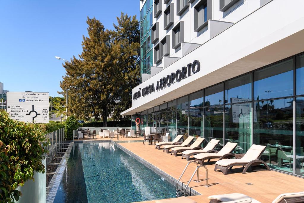 里斯本Meliá Lisboa Aeroporto的大楼前设有游泳池的酒店