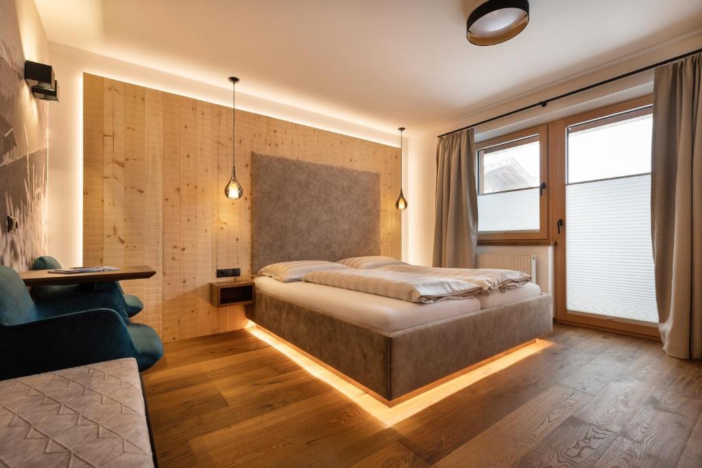 齐勒河谷采尔Hotel Garni Landhaus Platzer的一间卧室配有一张床、一张桌子和一张沙发