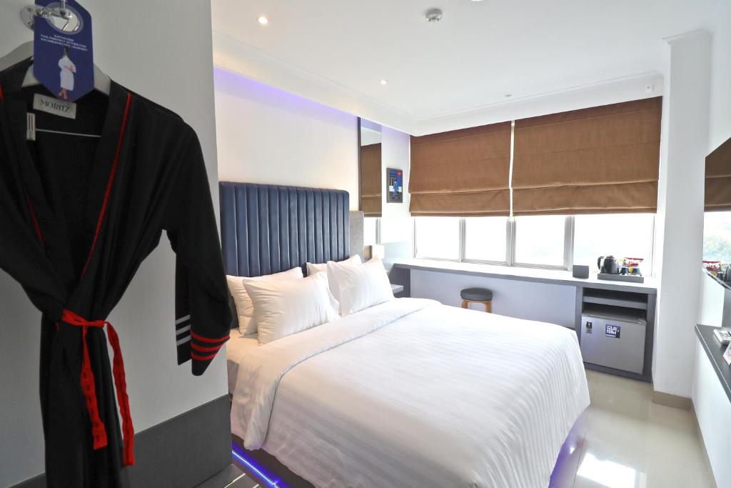 雅加达Moritz Biz Gandaria的一间卧室配有一张床,墙上挂着一个长袍