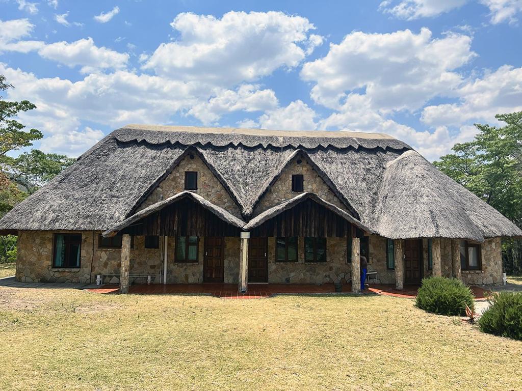 NyangaLovely house on 4 hectares in John Galt Village - 2011的田野上茅草屋顶的房子