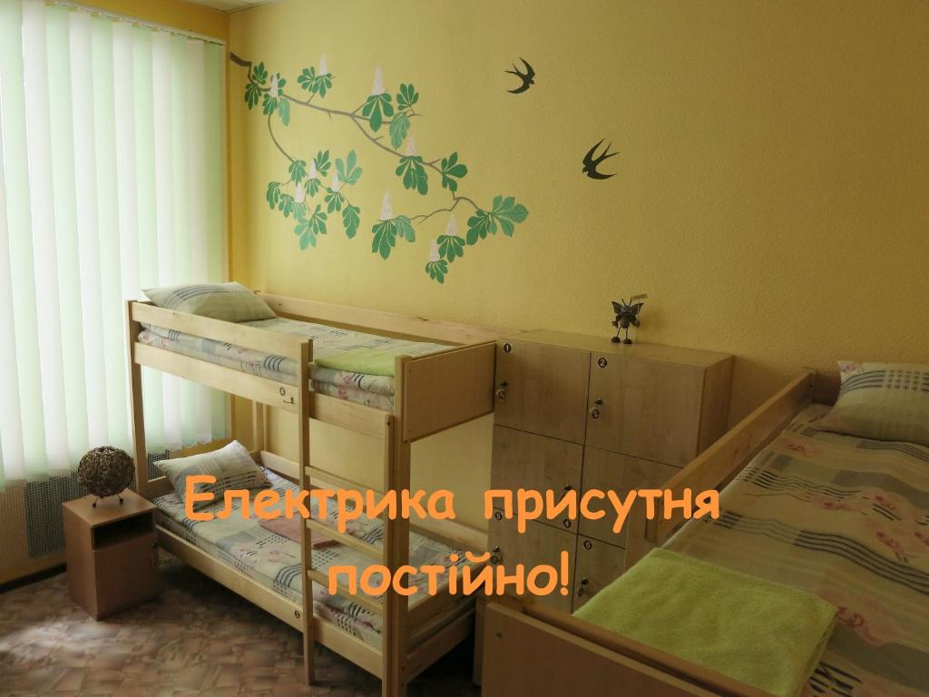 基辅德利尔旅馆的卧室配有两张双层床,墙上有鸟