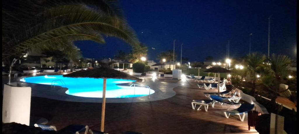 特吉塞Suite Bucica的夜间游泳池,配有椅子和遮阳伞