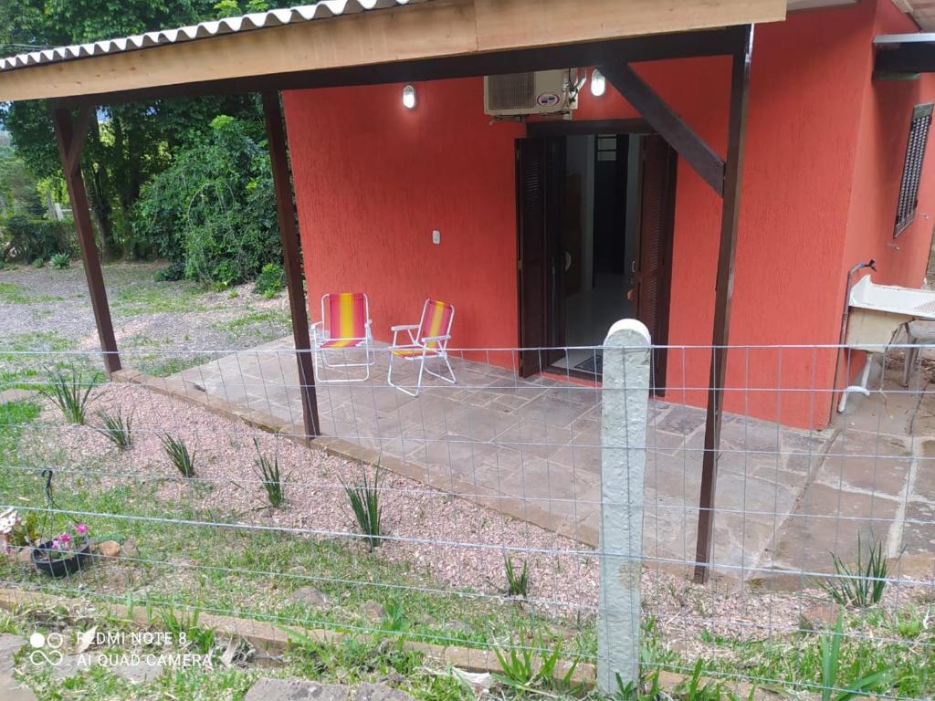 伊格雷日尼亚Casa Hermosa的前面有两把椅子的红色房子