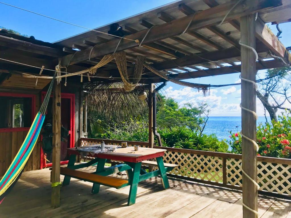 GuanajaGuanaja Backpackers Hostel的木甲板上设有野餐桌和吊床