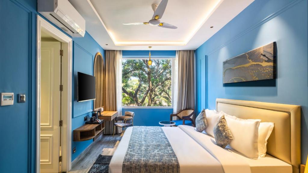 卡兰古特Renest Calangute Goa的蓝色卧室配有一张床和一张书桌