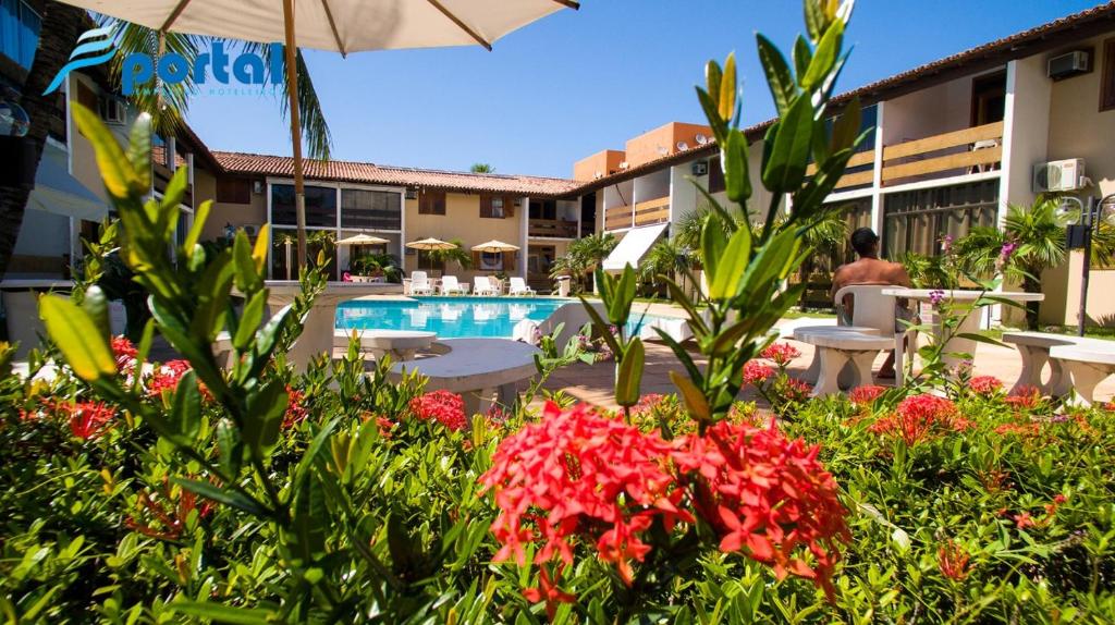 塞古罗港Apart Hotel Portal Do Atlântico - Portal Hotéis的一个带游泳池和一些鲜花的度假胜地
