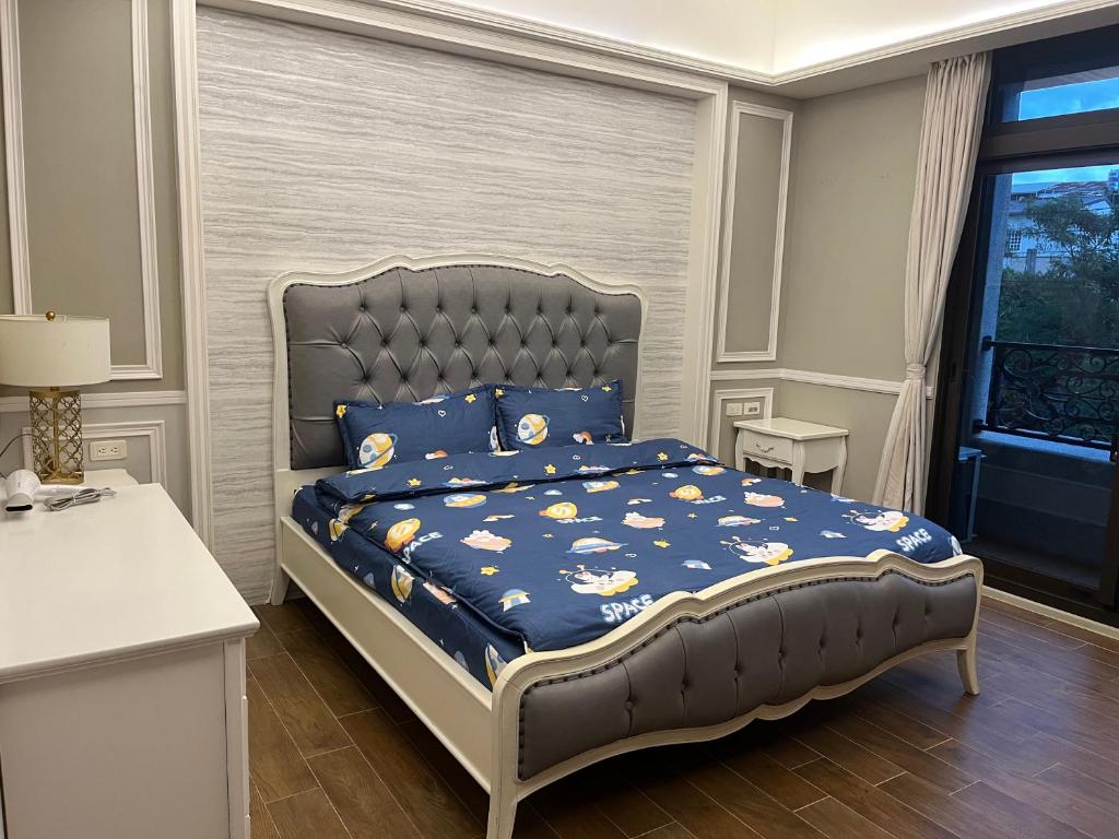 Beipu有间蛋宅的一间卧室配有一张带蓝色棉被的床