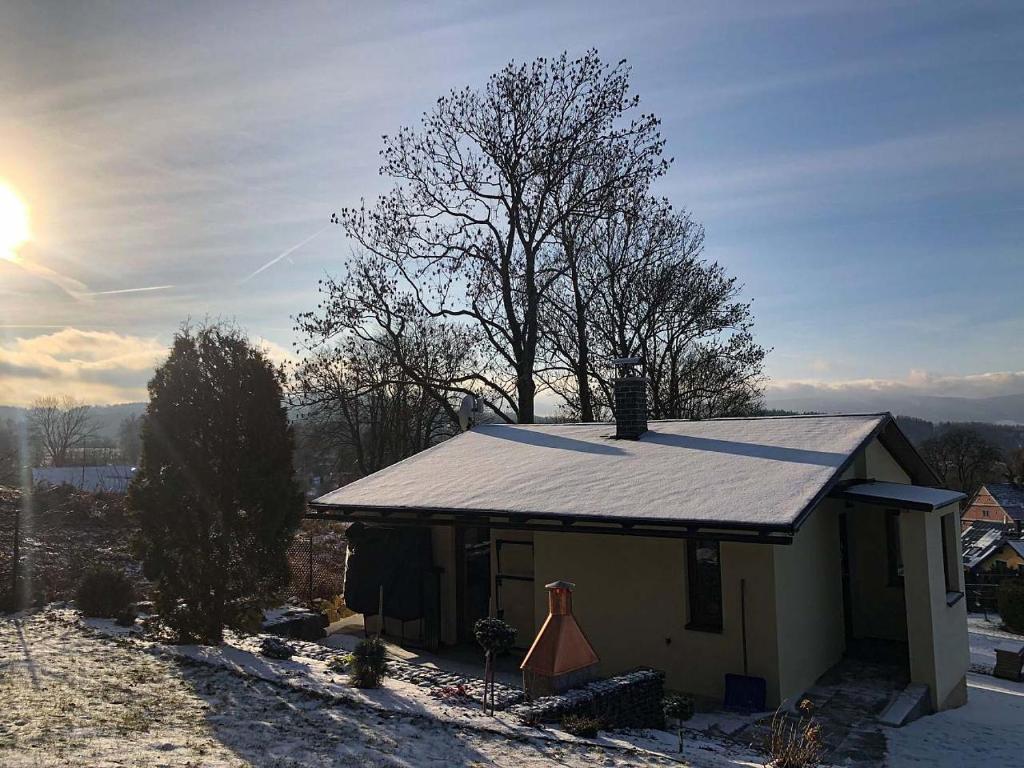 尼萨河畔亚布洛内茨Chata V Lukách的雪中带锡屋顶的小房子