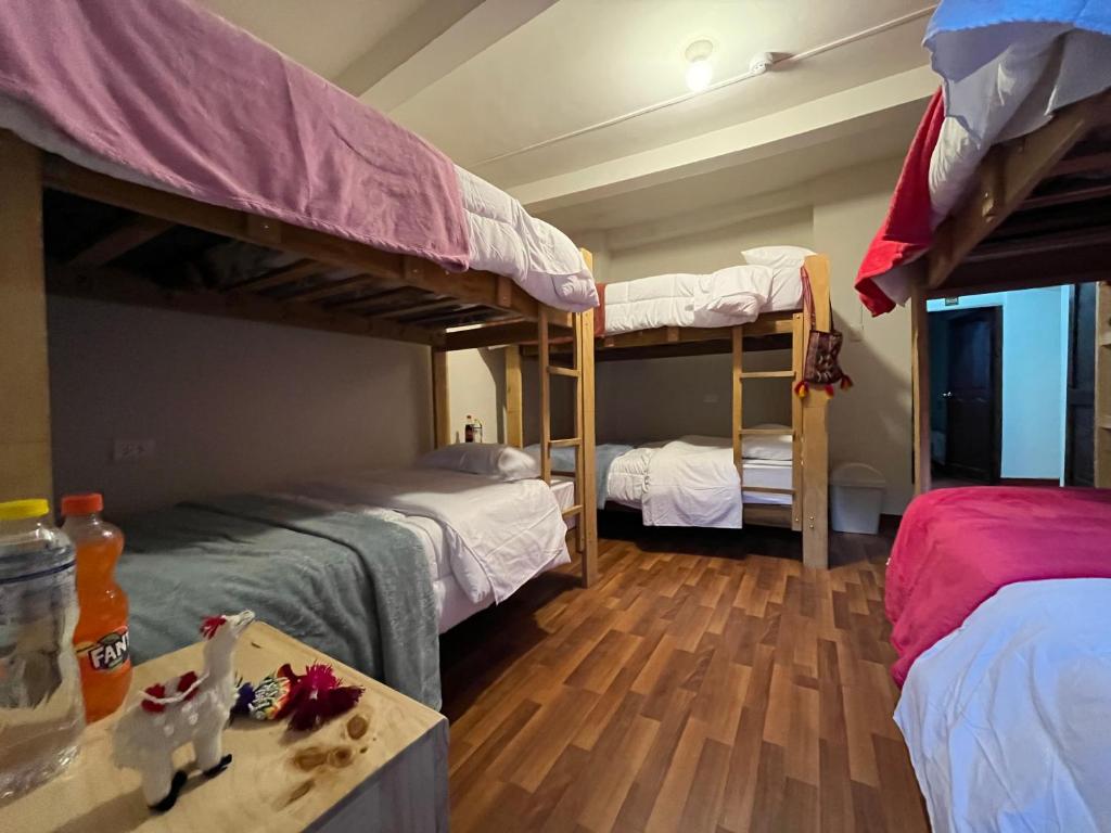 库斯科The Sleepy Mouse的客房设有两张双层床和一张桌子。