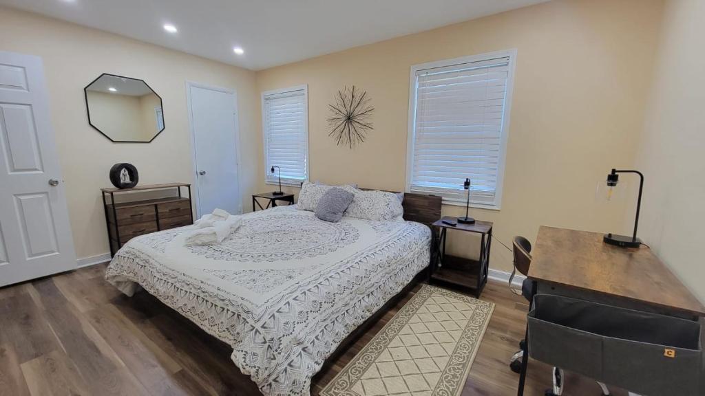 希尔顿黑德岛HHI Homes LLC的一间卧室配有一张床、一张书桌和两个窗户。